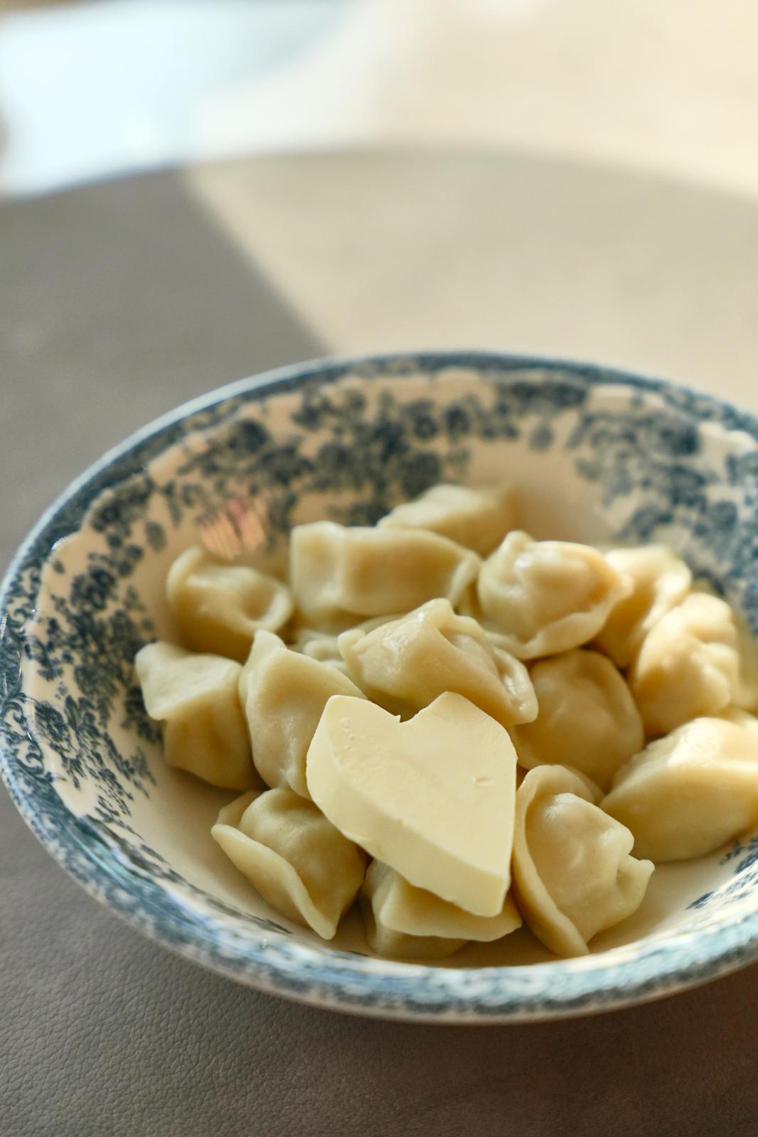 Schale mit Quarki Pelmeni, obenauf ein Stück Butter in Herzform
